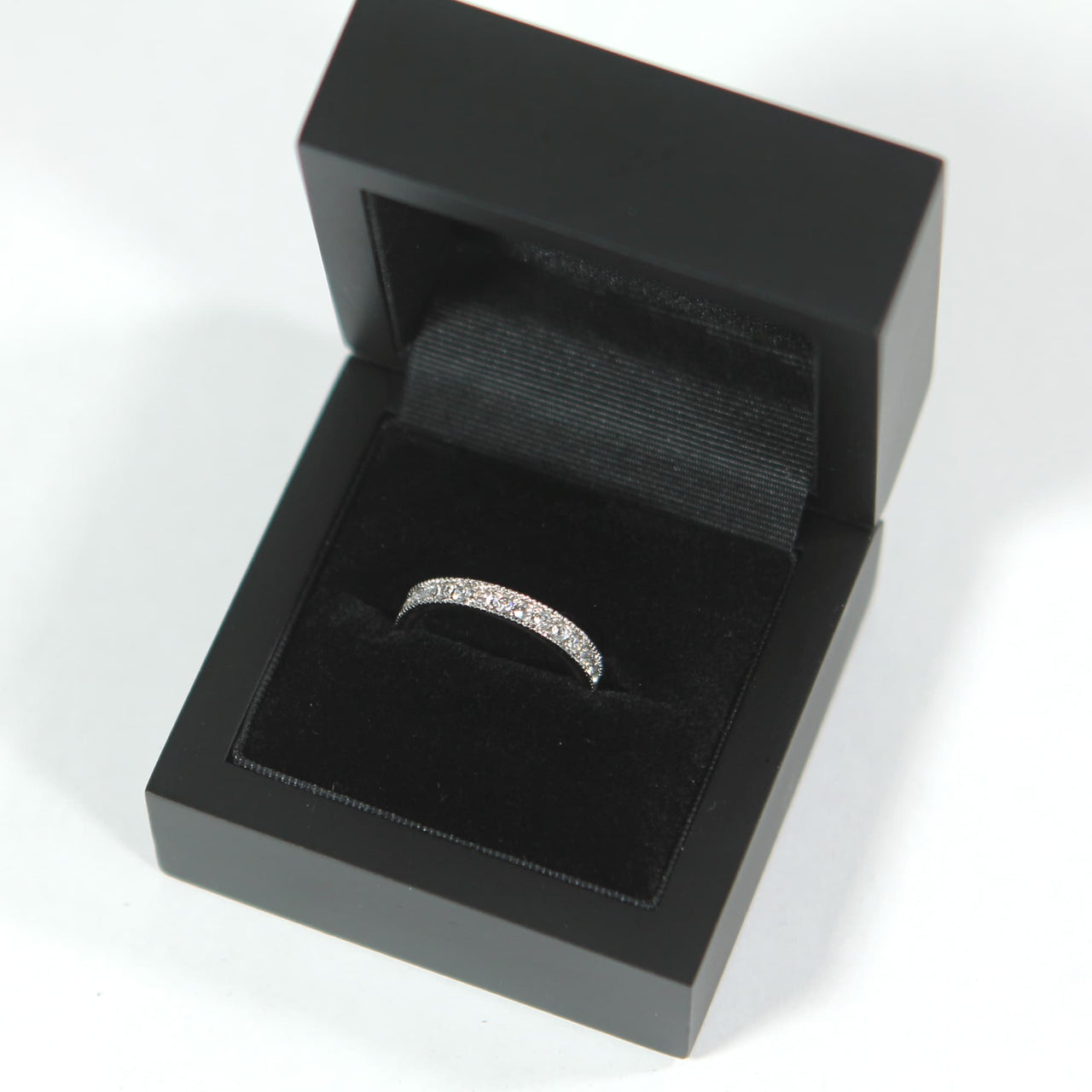 detailed shot of a wedding band in a premium black ring box 