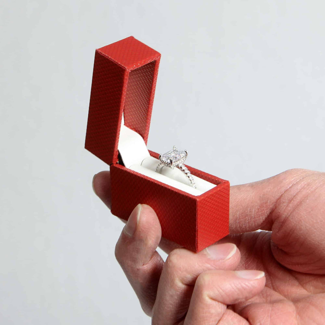 discreet red proposal ring box in hand