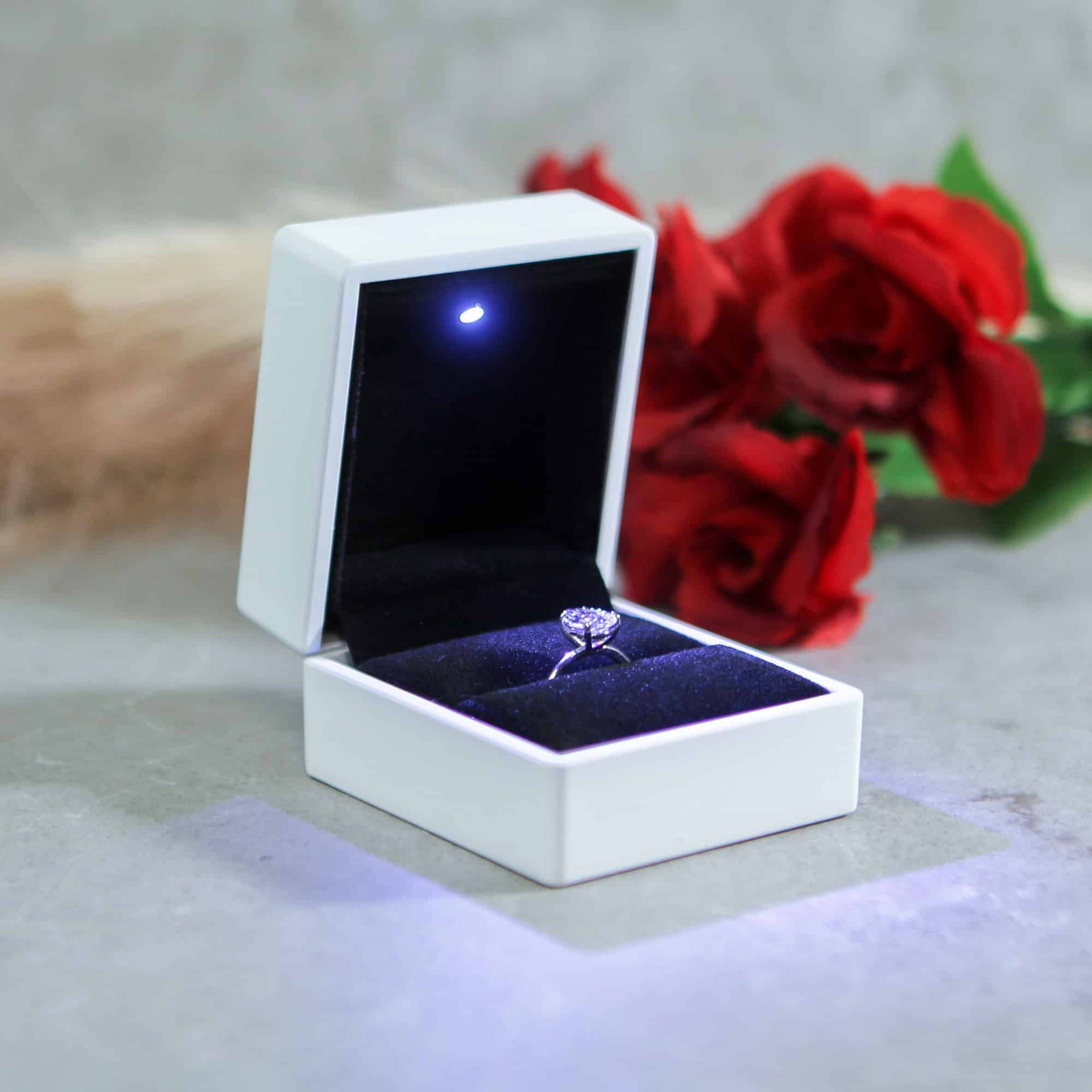 white proposal ring box with light and diamond engagement ring for proposal to her