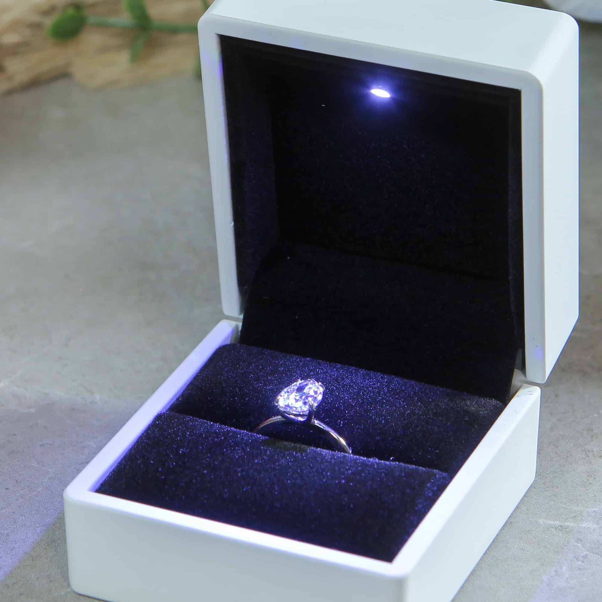white wedding ring box with oval diamond engagement ring and LED light