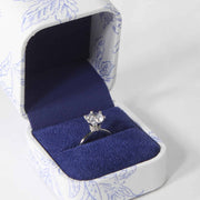 blue and white ring box with diamond ring