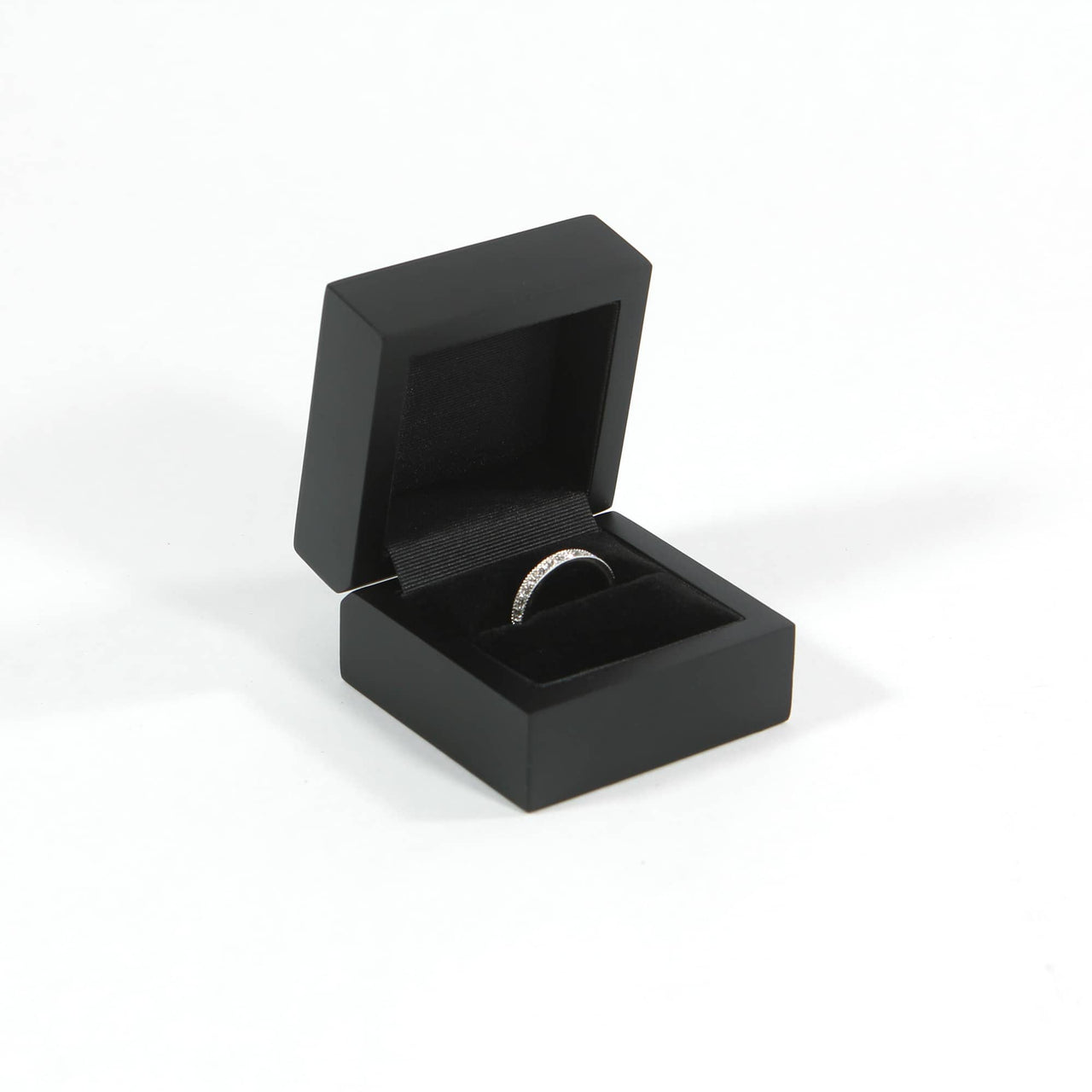 black proposal ring box with engagement ring placed within the ring slot made of velvet and wood
